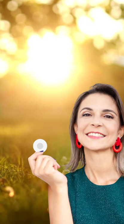 Alê Nogueira segurando o adesivo X39 ao pôr do sol